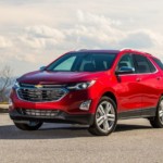 A red Equinox wins sits atop a mountain having won the 2019 Chevy Equinox vs 2019 Hyundai Santa Fe