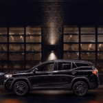 A 2019 black GMC Terrain is parked in front of a building at night.