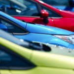 A closeup image of blue, green, and red cars.