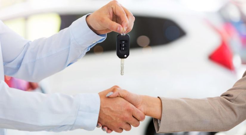Shaking hands while receiving car keys thanks to a buy here pay here program