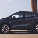 A black Encore drives in front of a bay after winning 2019 Buick Encore vs 2019 Nissan Kicks