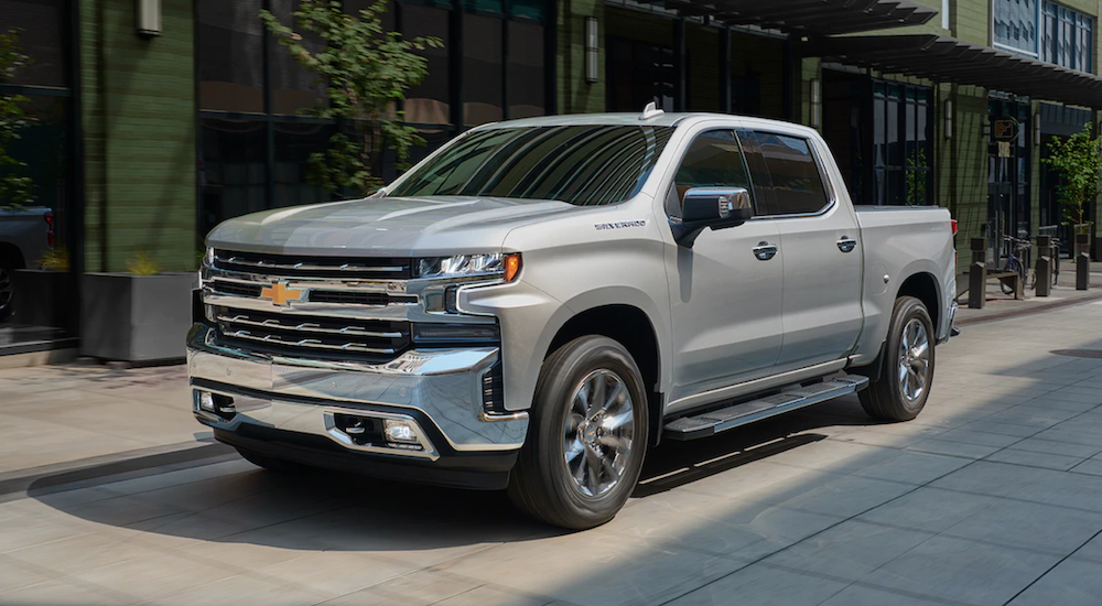 A silver 2019 Chevy Silverado 1500 is parked in front of a building. Check out power when comparing the 2019 Chevy Silverado vs 2019 Toyota Tundra.
