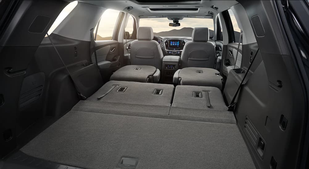 The grey interior of a 2019 Chevy Traverse is shown with the seats folded down. It has more room when comparing the 2019 Chevy Traverse vs 2019 Ford Explorer.