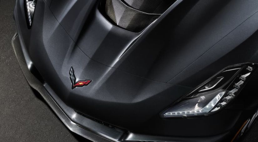 A close up of the hood emblem on a 2019 Corvette zr1 in black is shown. It hints towards the future release of the C8 in current auto news.