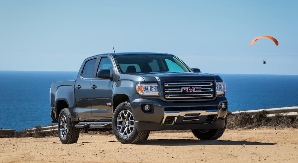 A grey 2017 GMC Canyon is parked at the beach. It is one of the used GMC trucks to check out.