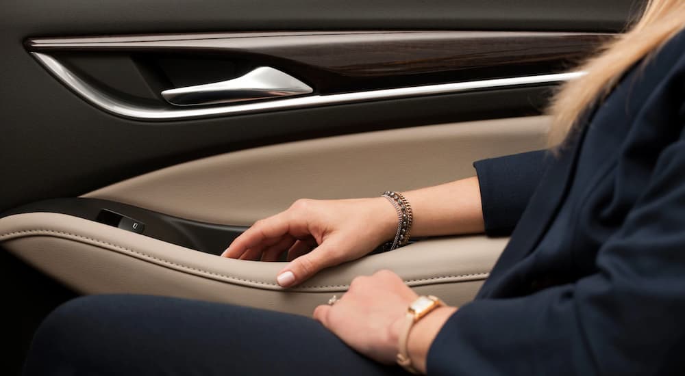 A close up of a woman's arm on the passenger door of the 2019 Buick Enclave is shown from the interior, which wins when comparing 2019 Buick Enclave vs 2019 Nissan Pathfinder.