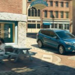 A blue 2019 Ford Escape is parked outside a sweets shop downtown.