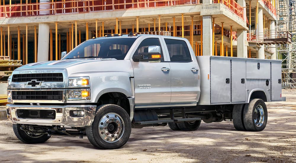 A 2019 Chevy 4500 Chassis Cab with a utility bed is at a construction site. 