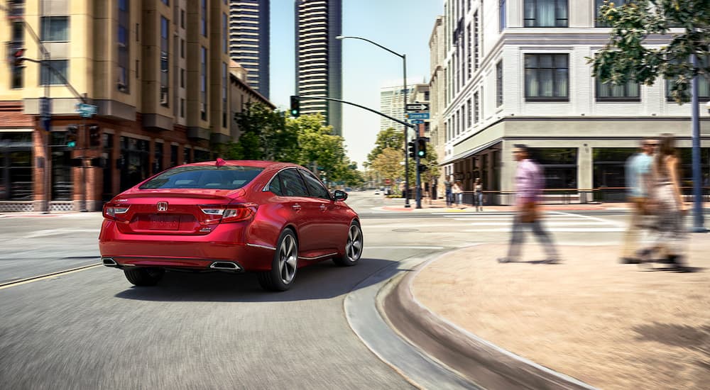 A red 2019 Honda Accord is taking a corner in a city.