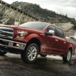 A dark red 2017 Ford F-150 Lariat is towing a boat out of the water. Check out this model and other used Ford trucks for sale.