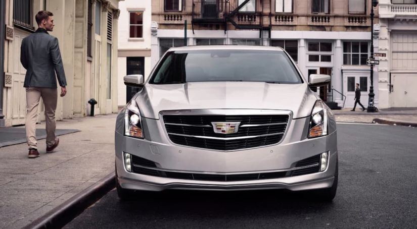 A silver 2019 Cadillac ATS is parked on a city street after leaving the Cadillac dealership.
