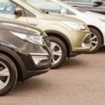 Cars are in a row at used car dealer's lot.