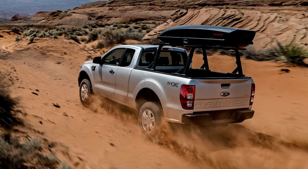 A silver 2019 Ford Ranger is driving through desert sand.