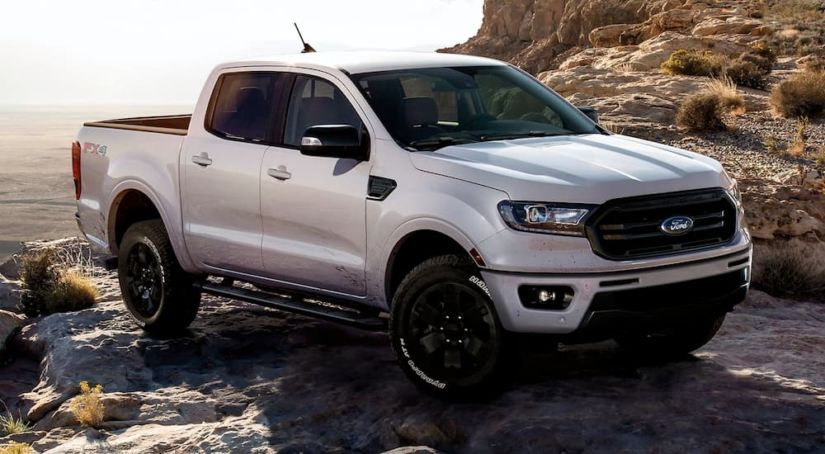 A silver 2019 Ford Ranger is parked on a rocky area with a view.