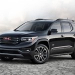 A black GMC Acadia, which wins when comparing the 2019 GMC Acadia vs 2019 Ford Explorer, is in a salt flat valley.