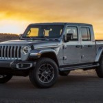 A grey 2020 Jeep Gladiator is parked with the sunset in the background.