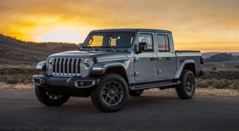 A grey 2020 Jeep Gladiator is parked with the sunset in the background.