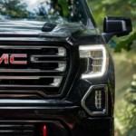 The front of a black 2019 GMC Sierra 1500 is shown in the woods outside Atlanta.