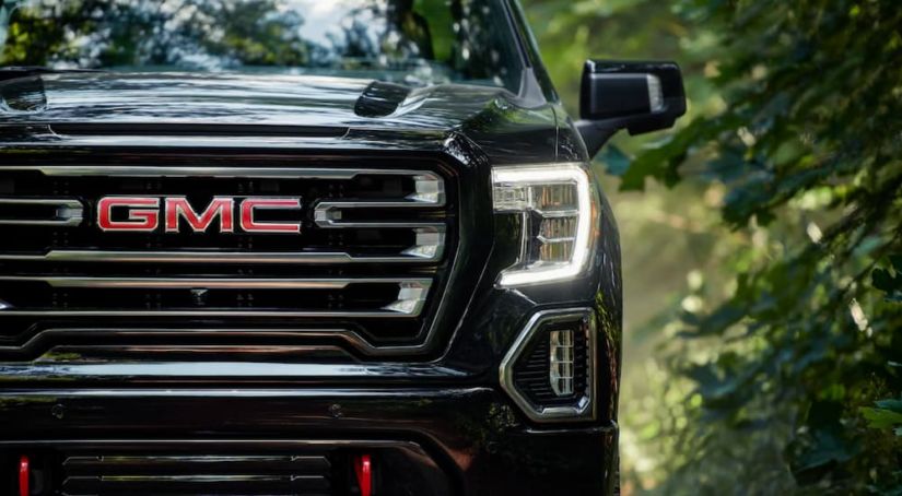 The front of a black 2019 GMC Sierra 1500 is shown in the woods outside Atlanta.