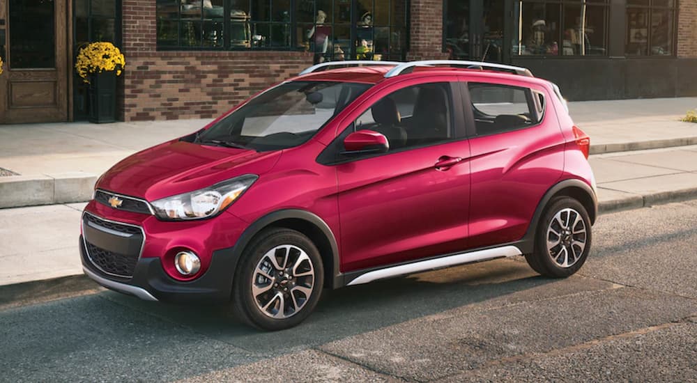 A dark pink 2019 Chevy Spark is on a city street.