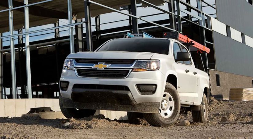 A white 2019 Chevy Colorado work truck is at a construction site.