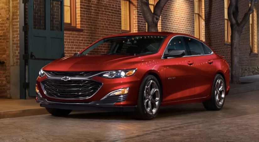 A red 2019 Chevy Malibu is parked downtown at night.