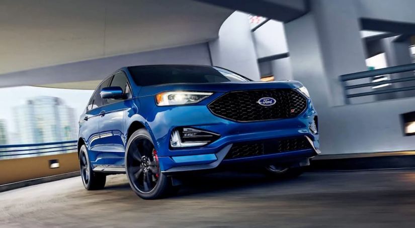A blue 2019 Ford Edge is rounding a corner in a parking garage.