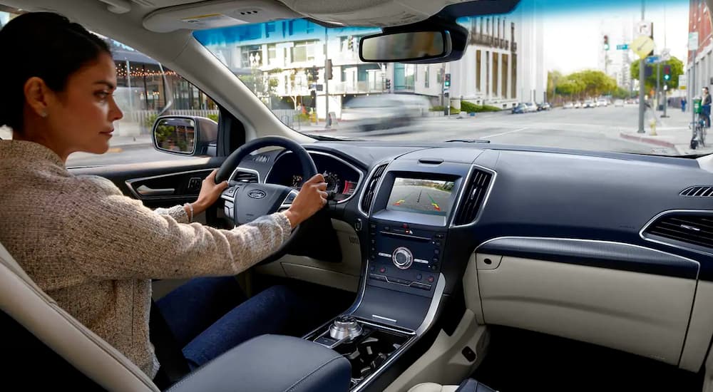A woman is using the back up camera view in her 2019 Ford Edge.