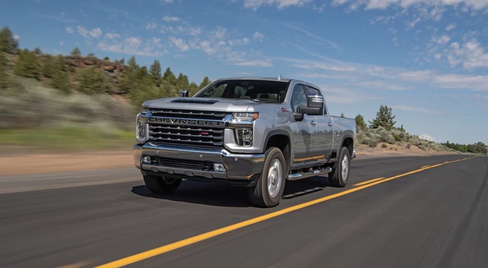 A grey 2020 Chevy Silverado 2500HD is driving on a highway.