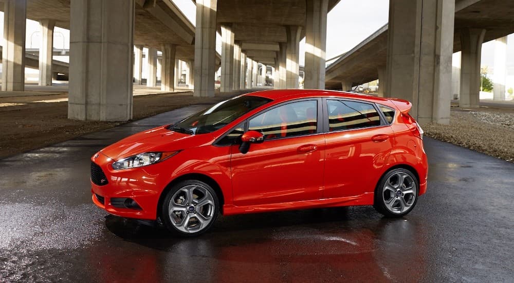 A red 2016 Ford Fiesta, popular among used cars in Cincinnati, is under an overpass.