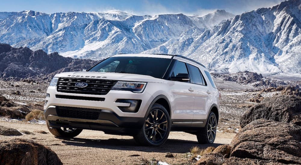 A white 2017 Ford Explorer is off-road in front of snowy mountains.