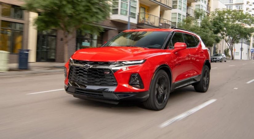 A red 2019 Chevy Blazer, which can be found at Texas top ten dealers, is driving down a city street.