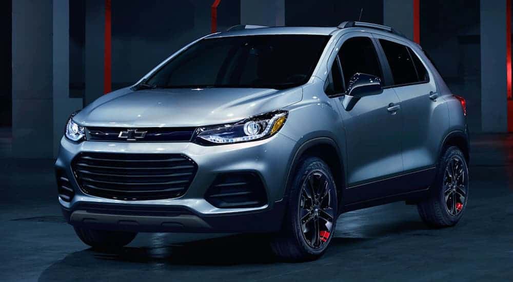 A silver 2020 Chevy Trax as the Redline Edition is parked in a dark lit garage.