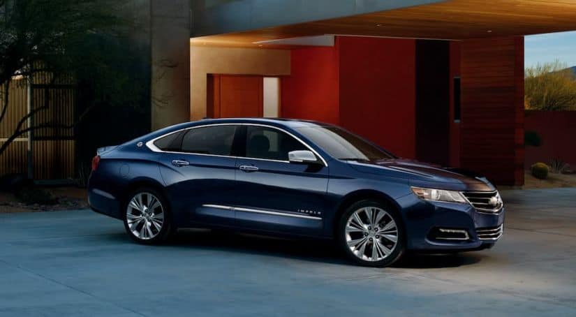 A blue 2019 Chevy Impala is parked in a driveway after leaving a Chevy dealership.