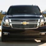 A black 2020 Chevy Suburban is shown from the front while driving down a highway.