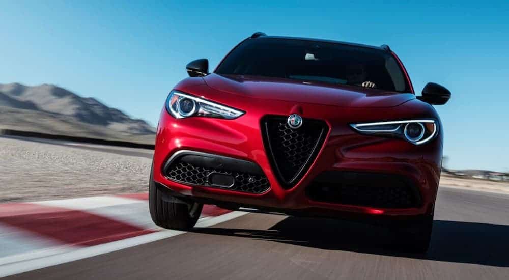 A 2019 red Stelvio is taking a corner on a racetrack. 