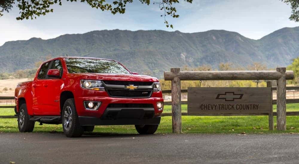A red 2019 Chevy Colorado, popular among Chevy Trucks in Albany, NY, is parked in front of a farm.
