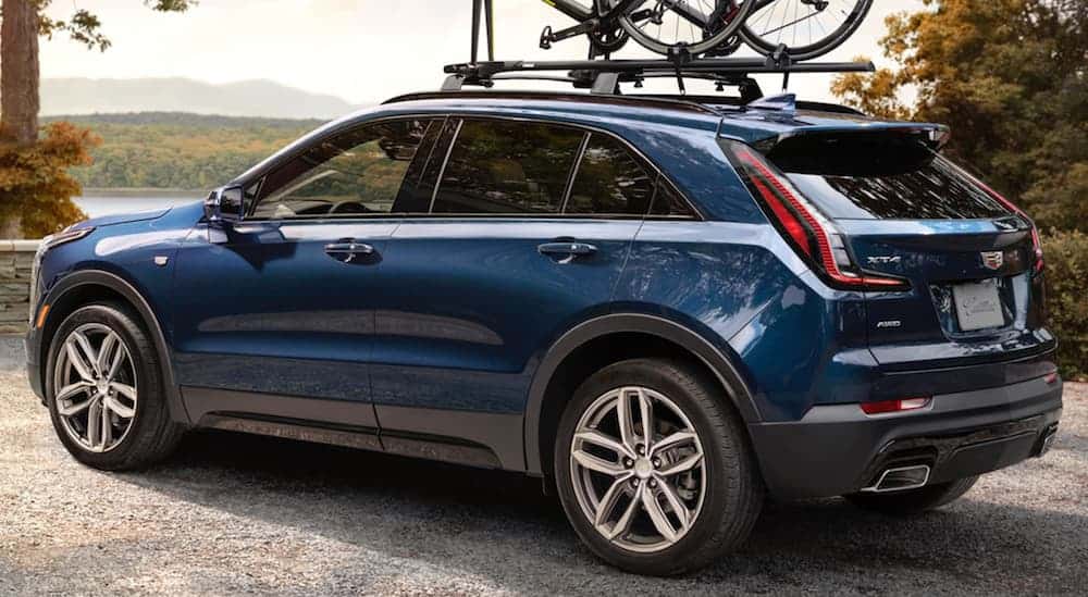 A side view of a blue 2020 Cadillac XT4 is shown with bikes on the roof racks.