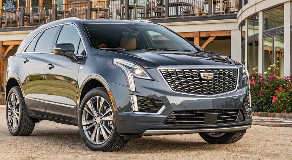 A blue 2020 Cadillac XT5 is parked in front of an outdoor restaurant.