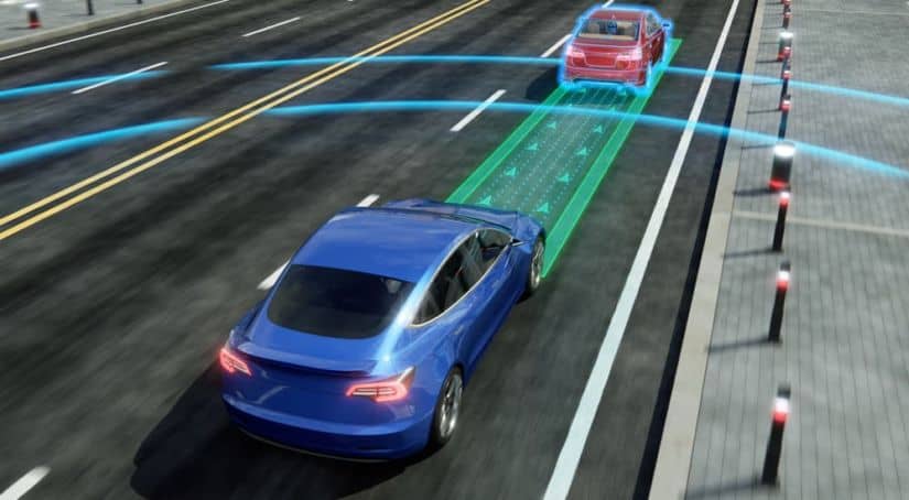 A blue car with simulated safety visuals is stopping by itself, which has been looked at for new driver safety laws in many different states, as it gets closer to a red car in front of it.