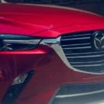 A close up of the front end of one of Mazda's top selling vehicles, a red CX-3.