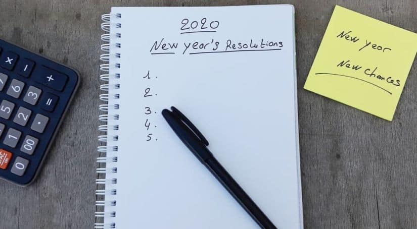 A pen is on a piece of paper that says "2020 New Years Resolution" on it.