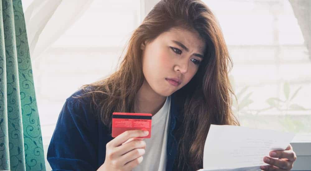 A woman is upset while looking at her bad credit score. 