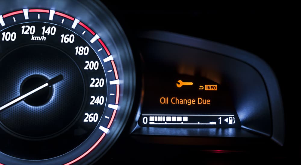A light on the dashboard of a car says 'oil change due'.