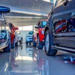 Two lines of used cars in a showroom.