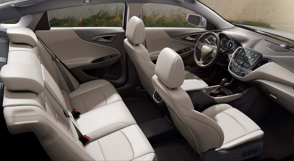 A birds eye view of the grey leather interior of a 2020 Chevy Malibu with an infotainment system is shown.
