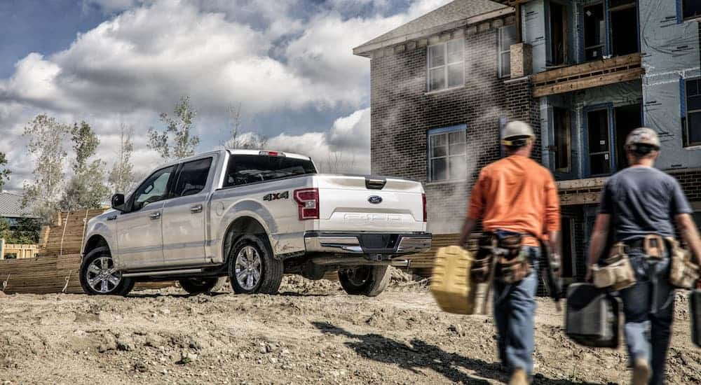 A white 2020 Ford F-150 is parked at a construction site.