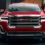 A red 2020 GMC Acadia is parked facing forward in a driveway.