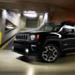 A black 2020 Jeep Renegade, which wins when comparing the 2020 Jeep Renegade vs 2020 Chevy Trax, is driving through a parking garage.