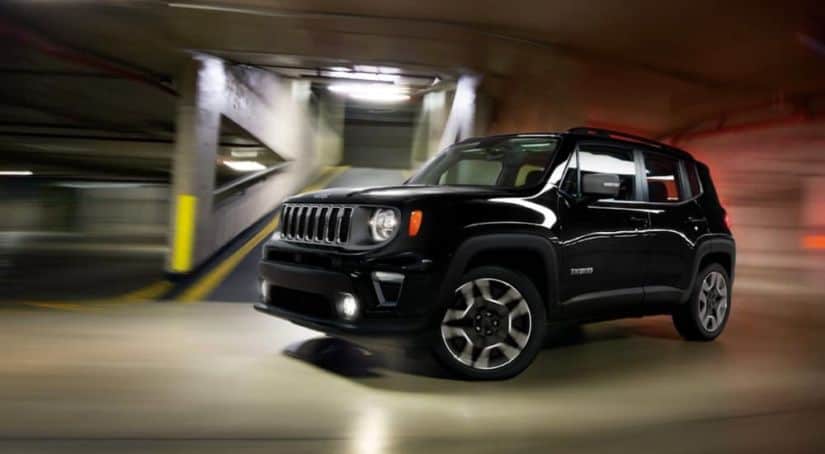 A black 2020 Jeep Renegade, which wins when comparing the 2020 Jeep Renegade vs 2020 Chevy Trax, is driving through a parking garage.